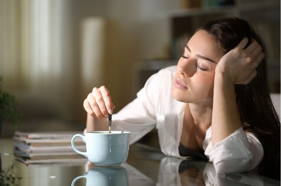 Persona bostezando con taza de café por la mañana