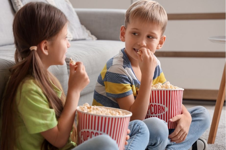 Niños disfrutando juntos de una película infantil clásica en casa