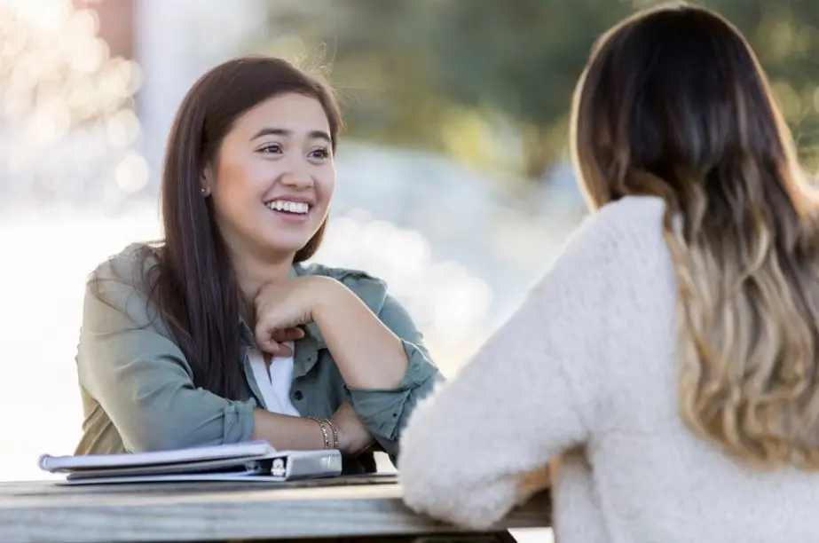 Dos mujeres conversando mientras una escucha con atención y empatía