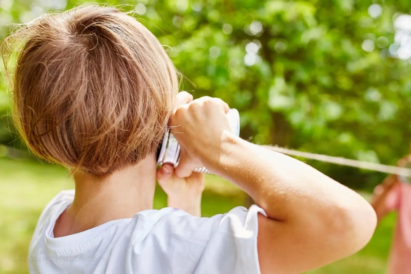 Niños jugando con teléfonos de lata para representar la escucha activa y la comunicación