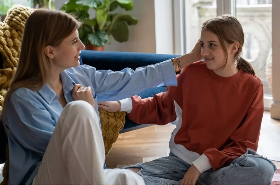 Madre escuchando y acompañando emocionalmente a una adolescente durante una conversación