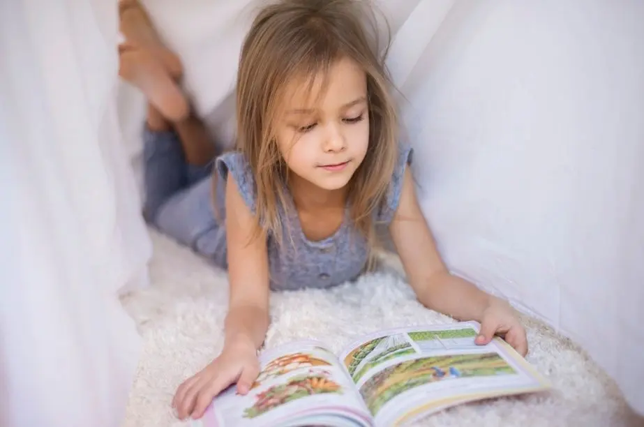 Niña leyendo un libro para mejorar la comprensión lectora