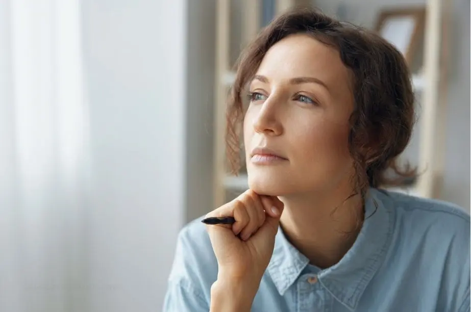 Mujer reflexionando sobre coincidencias y patrones relacionados con supersticiones