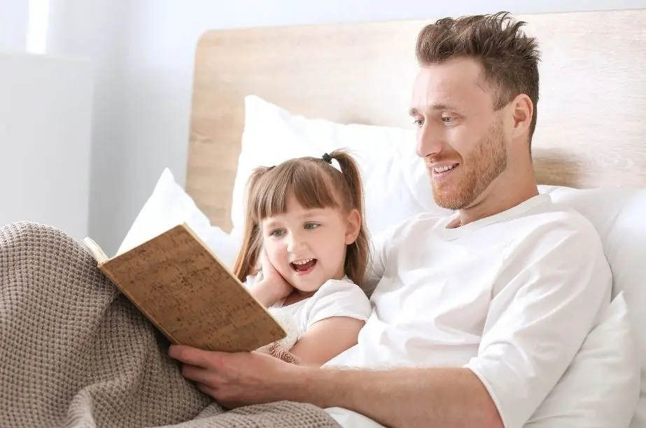 padre leyendo con su hija un libro infantil en un ambiente tranquilo