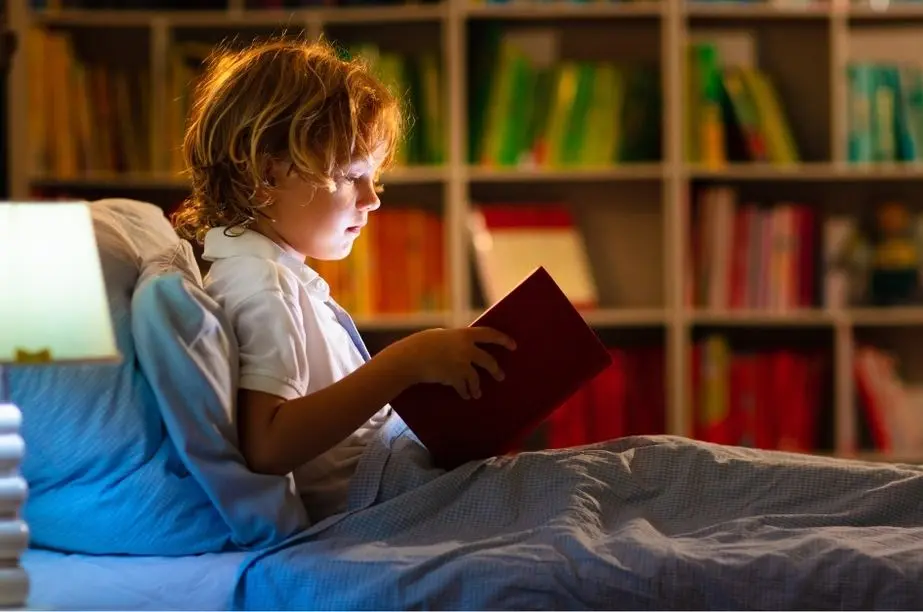 niño leyendo libro por la noche con luz cálida en un entorno seguro