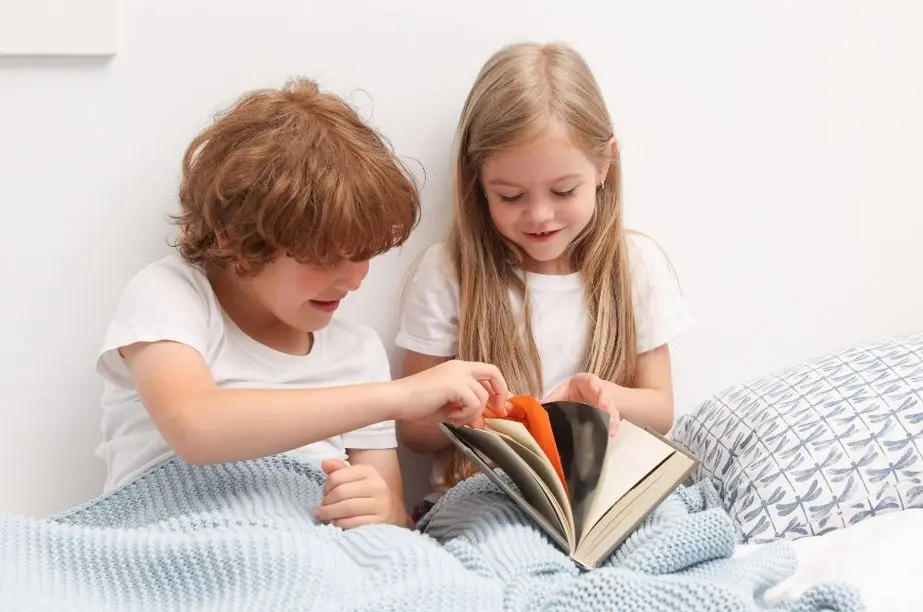 dos niños leyendo juntos un libro infantil en un ambiente tranquilo