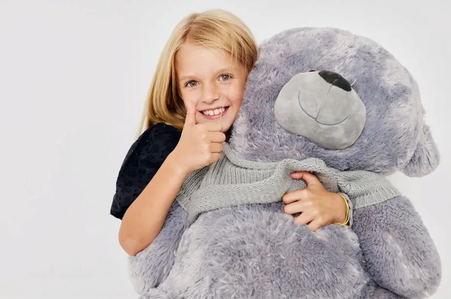 Niña abrazando un peluche gigante
