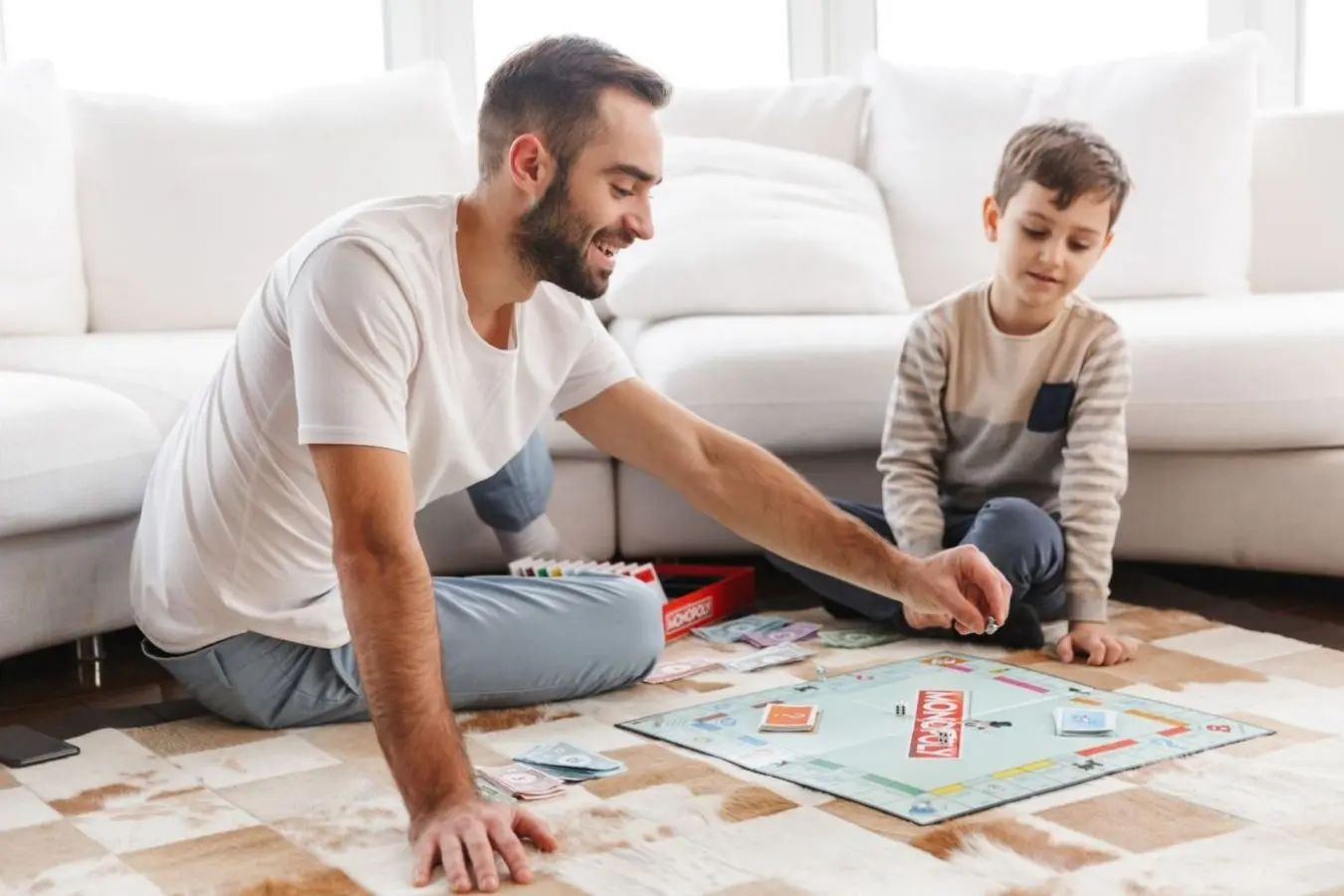 padre jugando al Monopoly con su hijo en casa