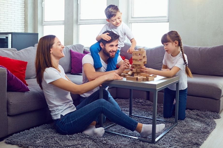 Familia jugando a un juego de mesa en casa en ambiente relajado