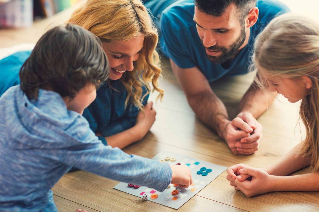 Familia jugando a juegos de mesa educativos en casa con niños