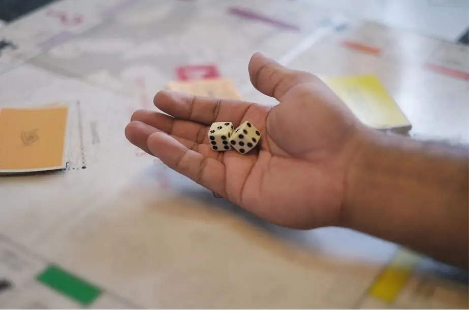 mano lanzando dados en una partida de Monopoly