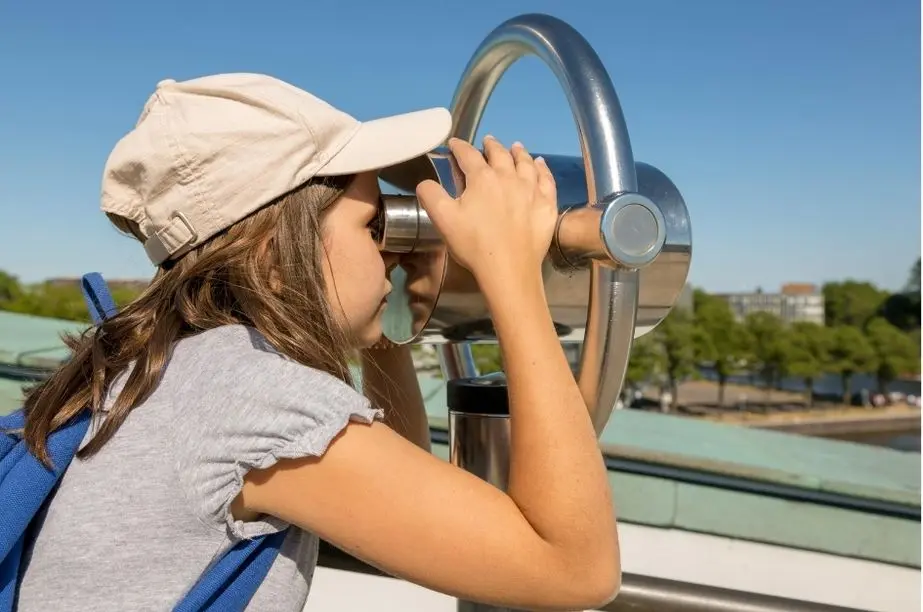 Niña observando con un catalejo