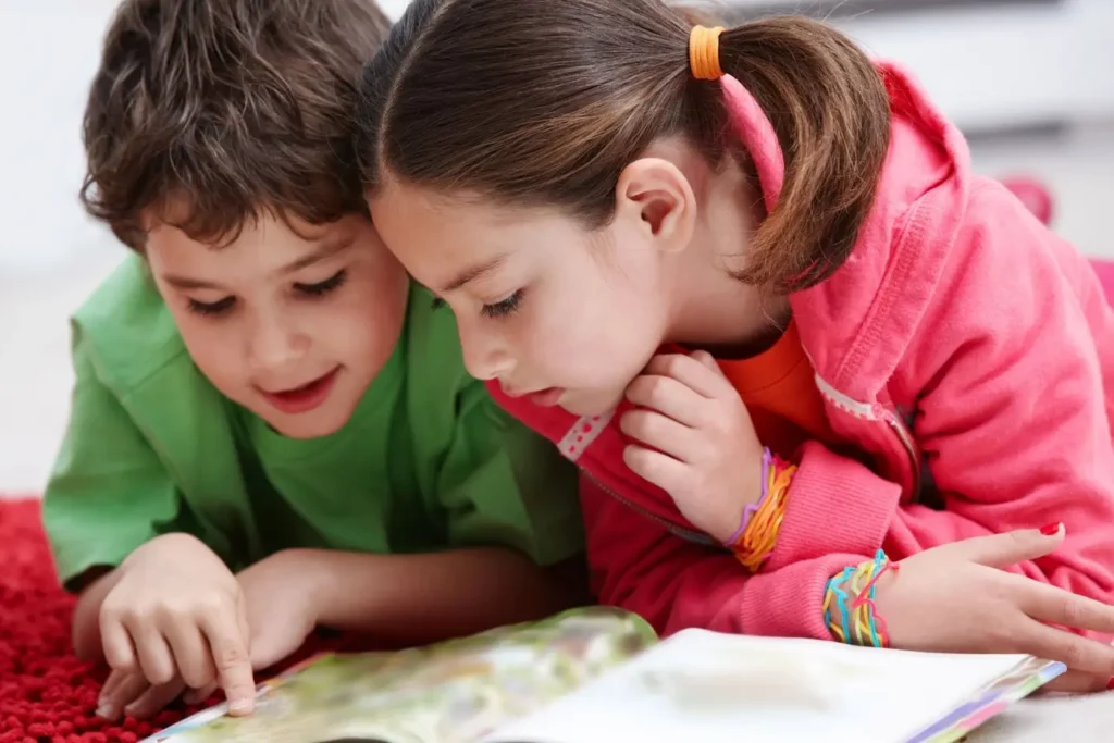 Dos niños leyendo juntos un libro informativo