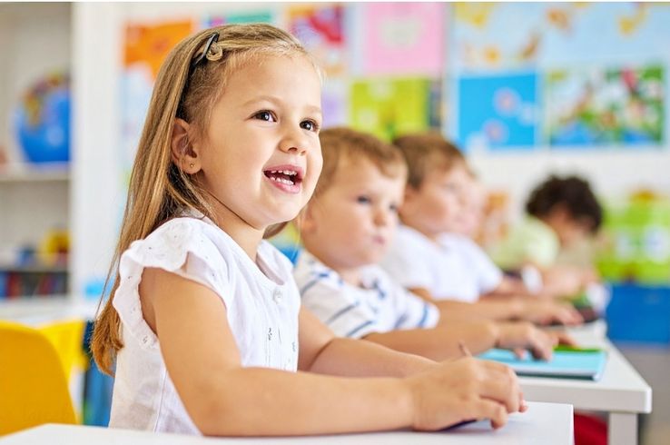 Niña sentada tranquila haciendo respiración guiada en clase