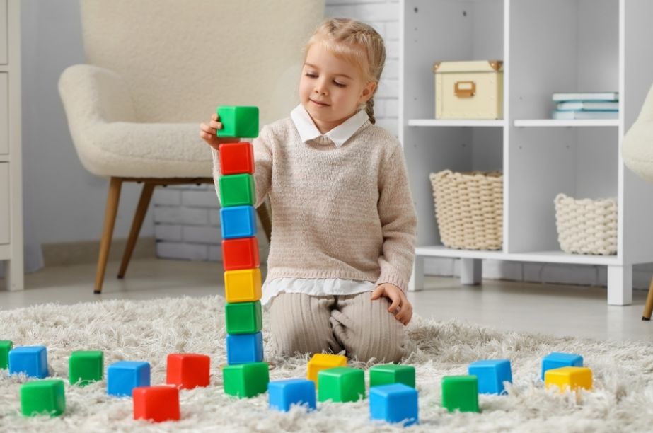 niña construyendo una torre de bloques como ejemplo de resiliencia infantil