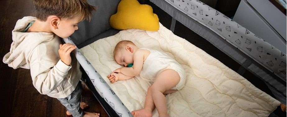 Bebé descansando plácidamente en una cuna de viaje