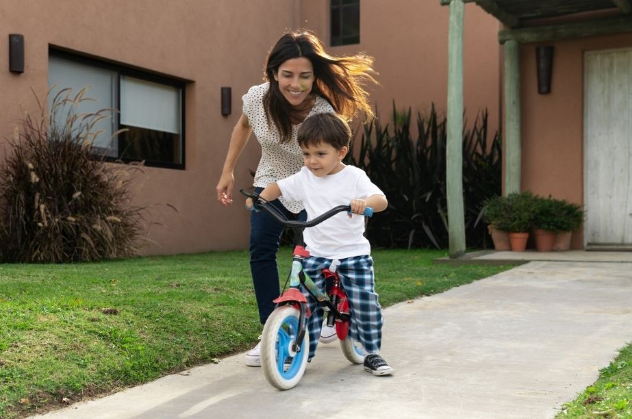 Mamá acompañando a su hijo en bici sin pedales
