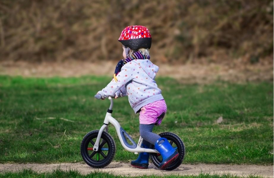 Niño de 2 años usando bicicleta de equilibrio infantil