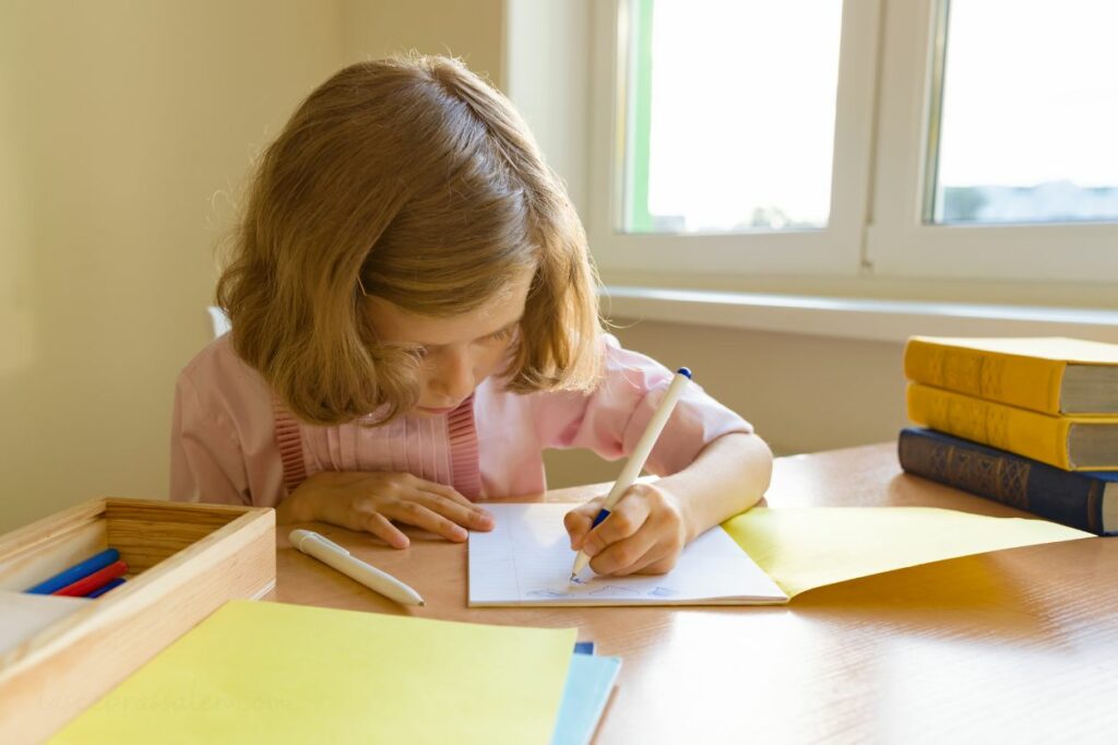 Niño zurdo escribiendo con dificultad durante el aprendizaje de la escritura