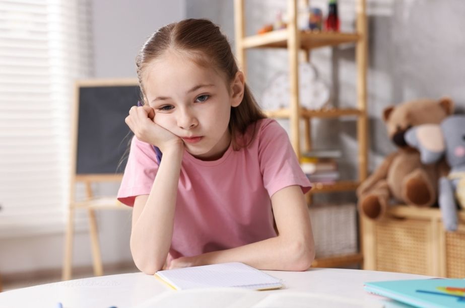 Niña de primaria estudiando en casa con gesto pensativo, relacionada con falta de hábitos de estudio en altas capacidades