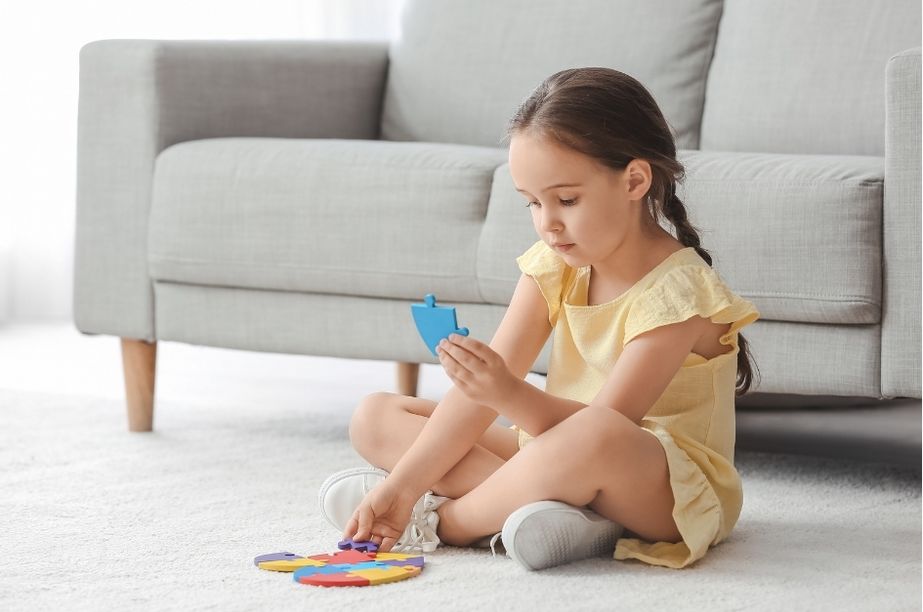 Niña de 5 años concentrada resolviendo un puzle, una posible señal de altas capacidades