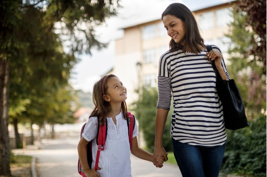 Madre acompañando a su hija de primaria camino del colegio, apoyo familiar en niños con altas capacidades.