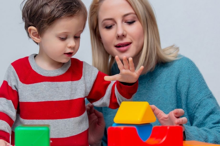 madre observando a su hijo mientras juega con bloques durante el proceso de detección de altas capacidades