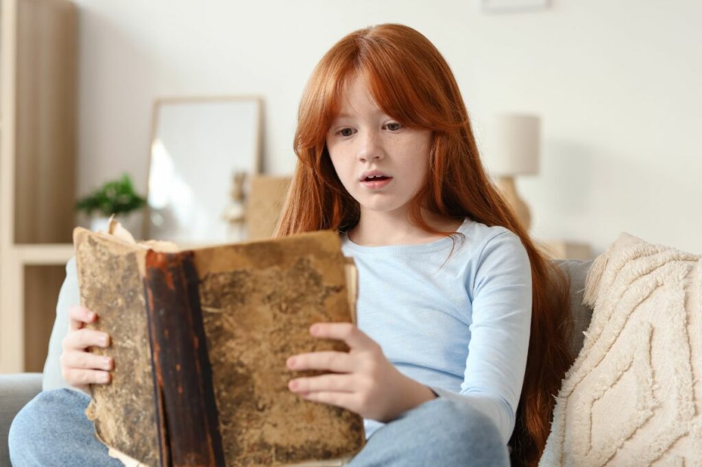 Niña leyendo un libro en casa en un ambiente tranquilo