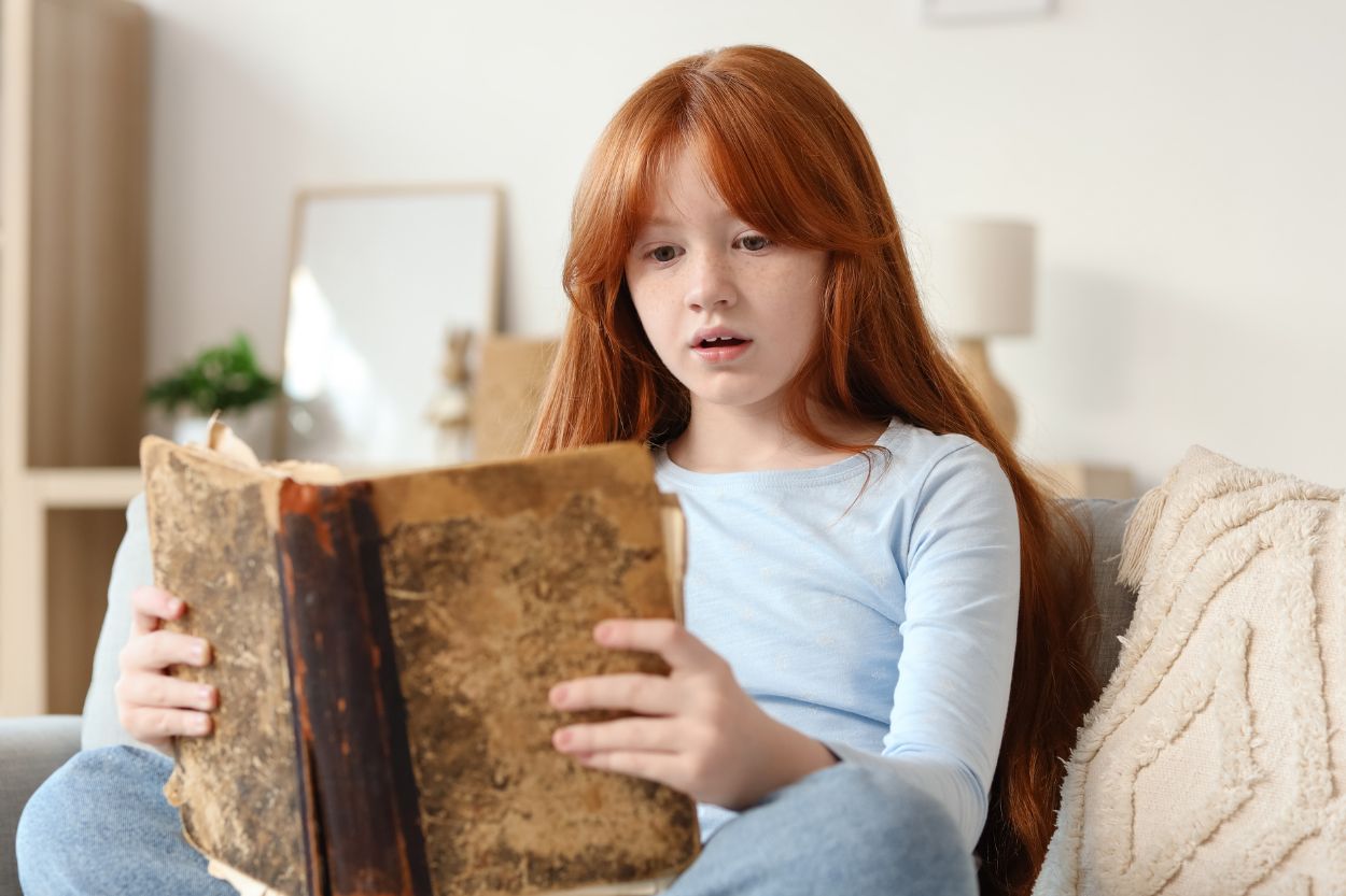 Niña leyendo un libro en casa en un ambiente tranquilo