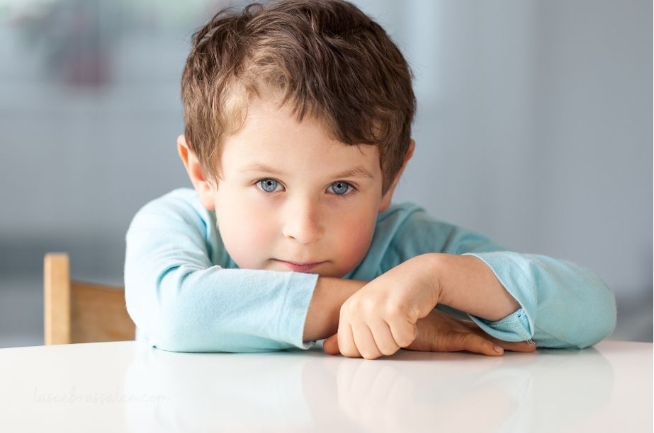 Niño de 6 años pensativo apoyado en una mesa, reflejo de sensibilidad emocional y mundo interior profundo