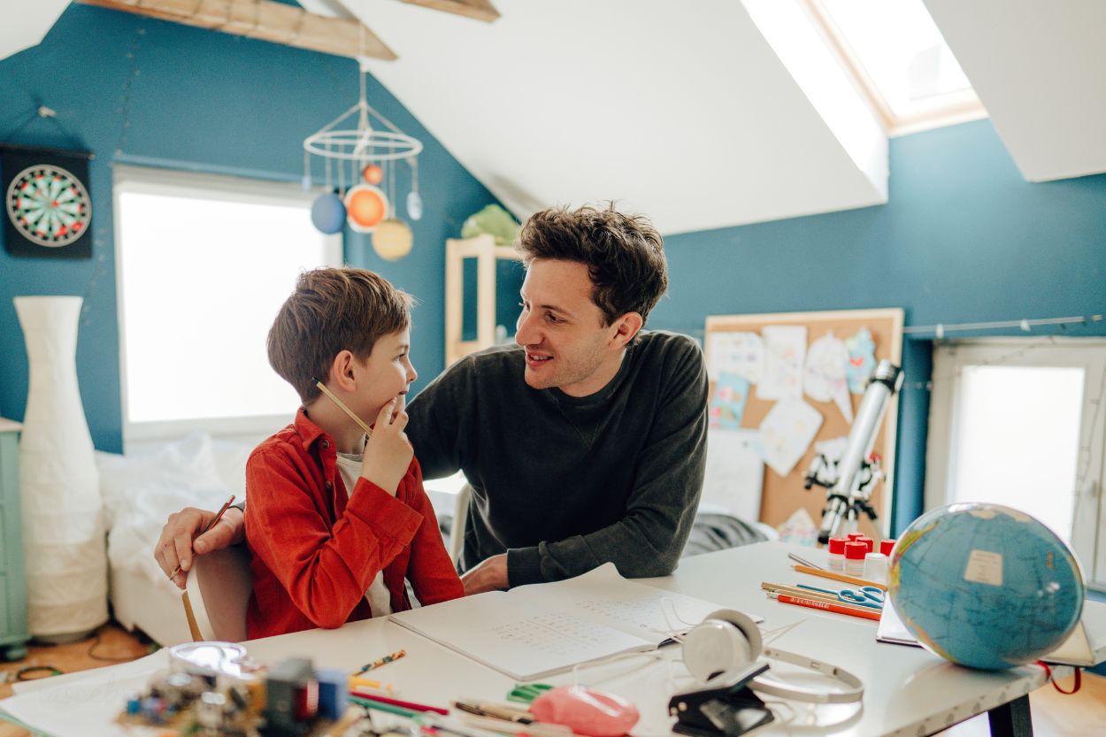 Padre acompañando a su hijo durante una actividad educativa en casa
