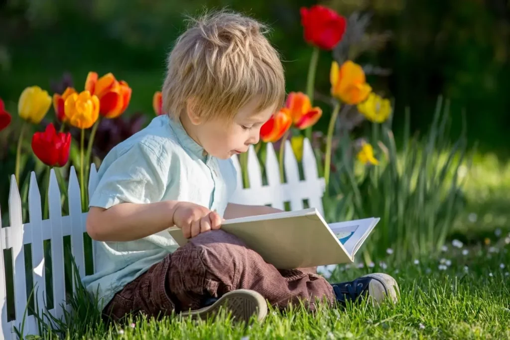 niño leyendo libro en el jardín aprendizaje valores el principito