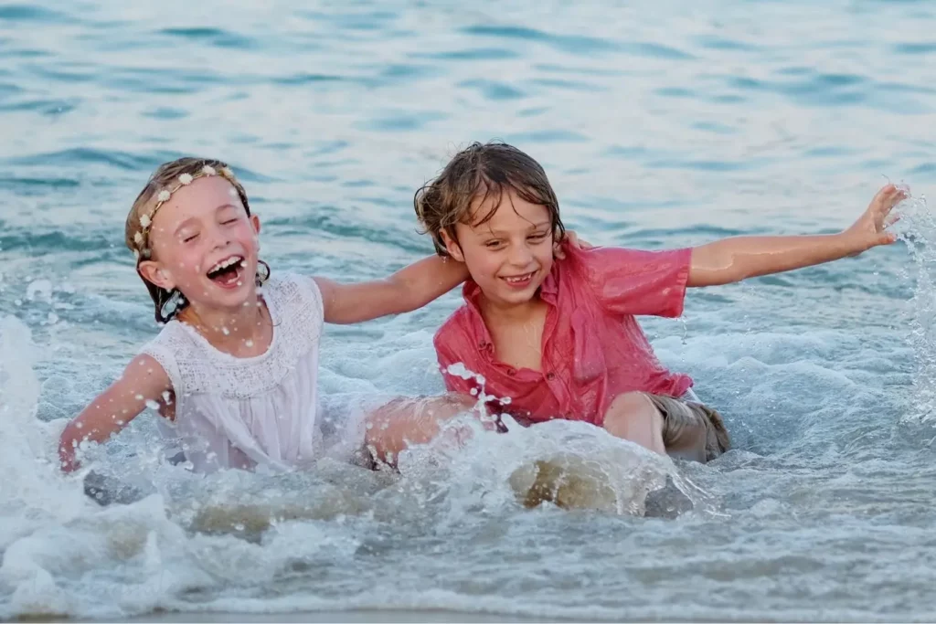 Niños jugando en la playa con ropa de verano cómoda y ligera