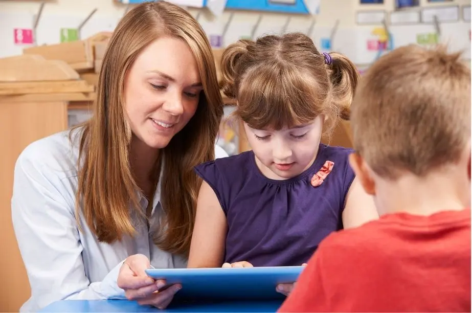 Profesora con una alumna de Primaria utilizando una tablet en el aula