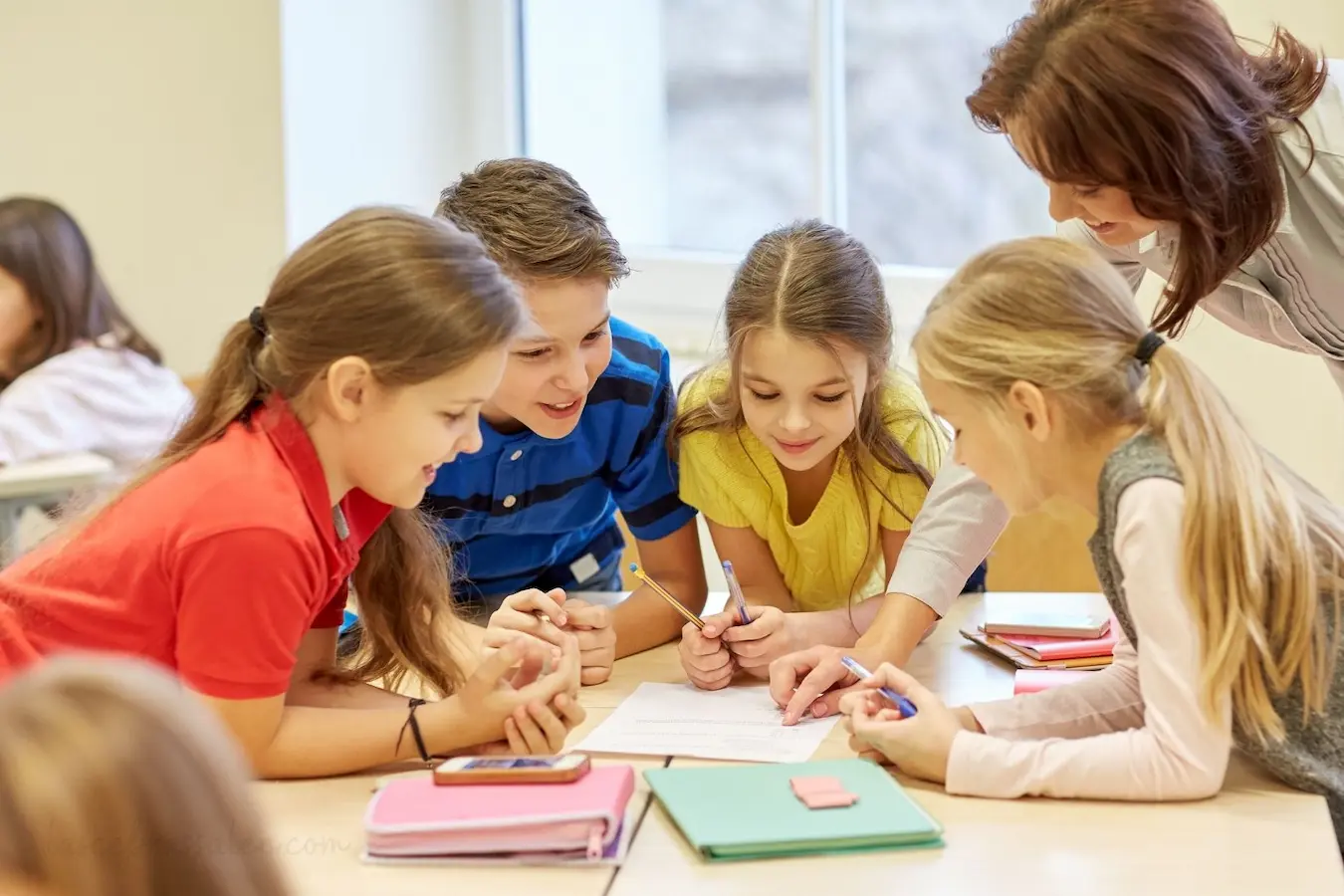 Profesora con alumnos de Primaria trabajando en el aula