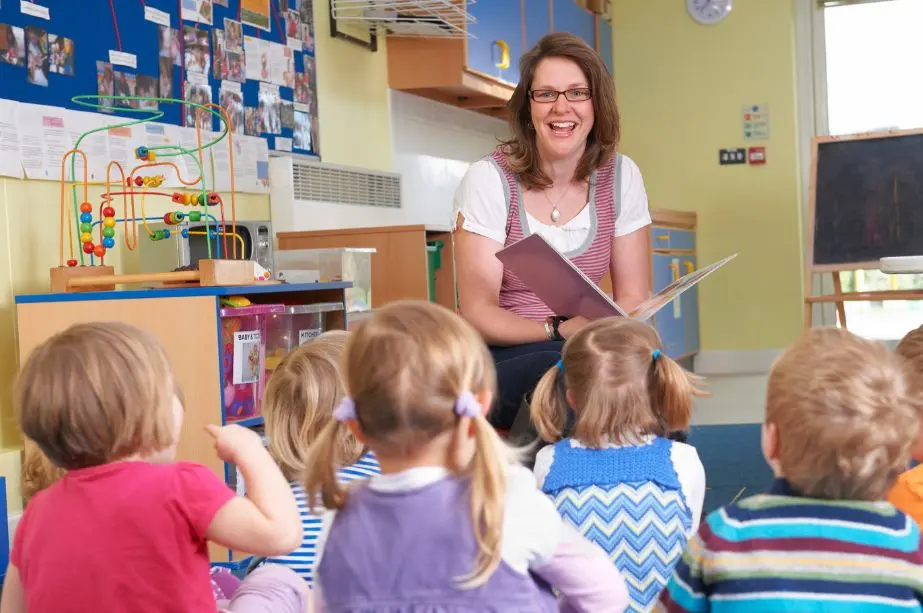 Docente leyendo un cuento infantil con niños en el aula