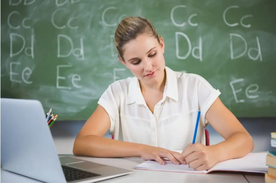 Docente trabajando con ordenador en el aula