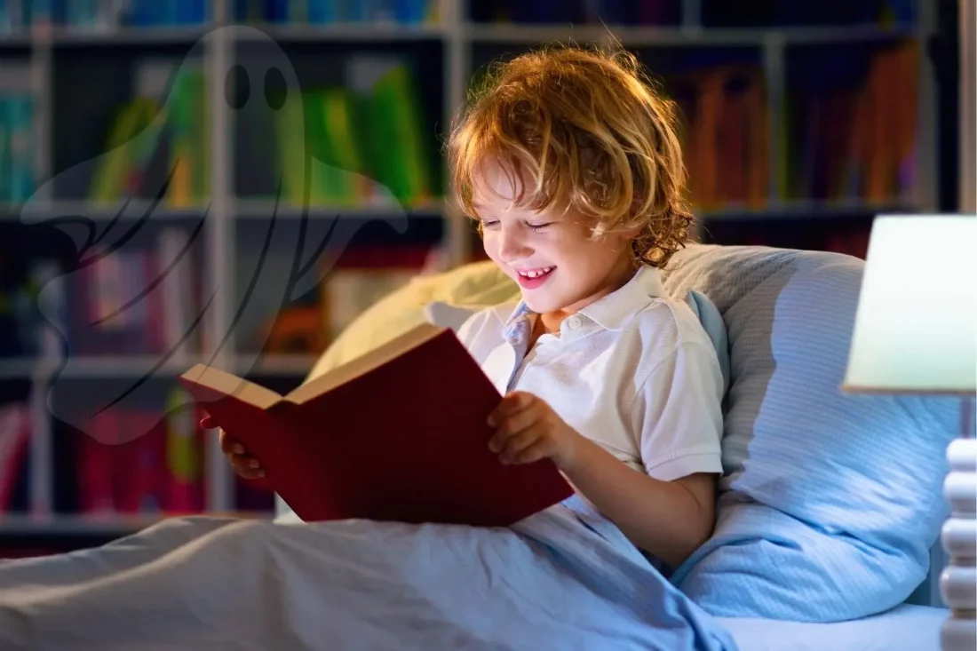 niño leyendo un libro por la noche con una sombra de fantasma suave al fondo libros de miedo para niños