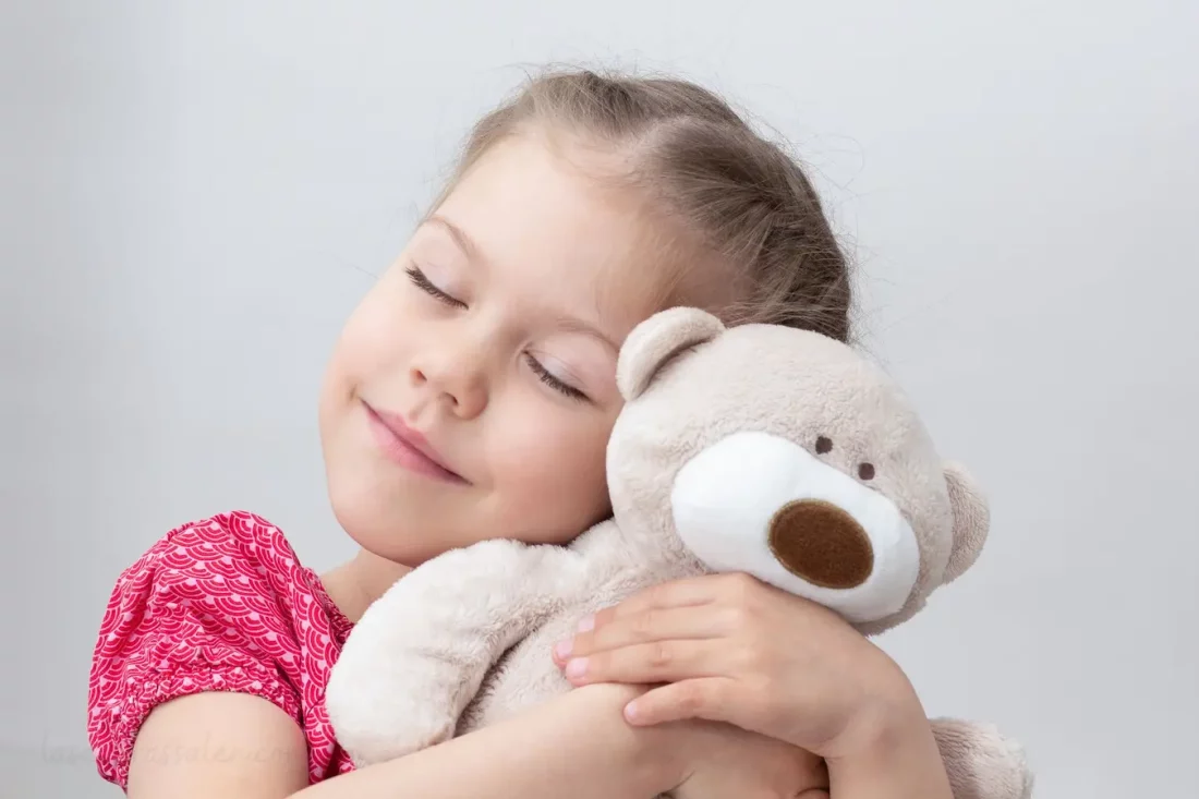 Niña abrazando un oso de peluche