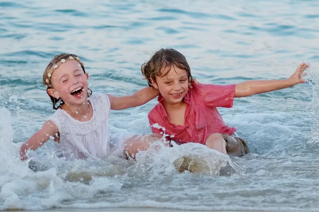 Niños jugando en la playa con ropa de verano cómoda y ligera